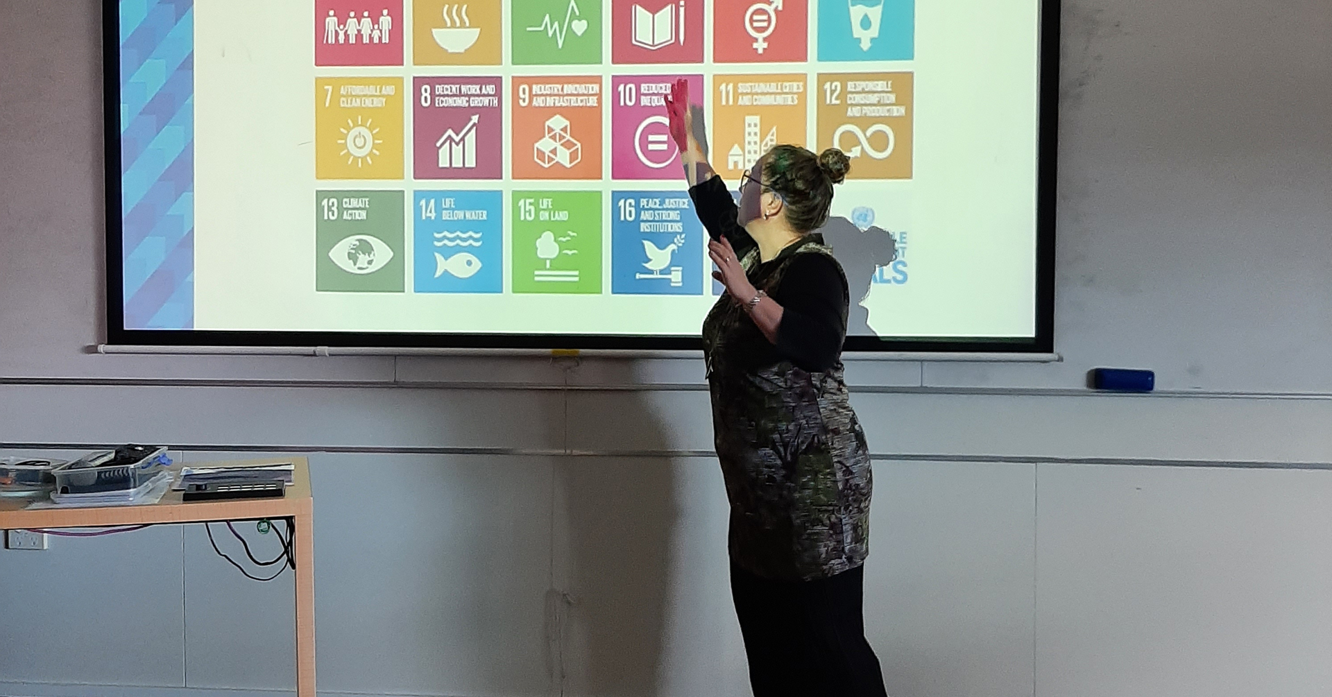 Image of Kim Daly pointing at the SDGs on a projected image.