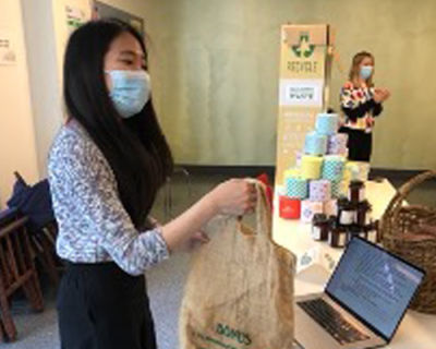 Image of Ru Hui Foong giving a bag back to a customer at a sustainability event.